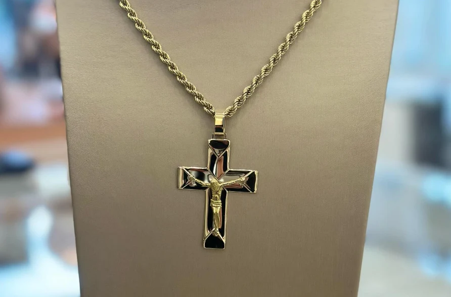 Immagine originale: pendente a croce su un espositore per collane.