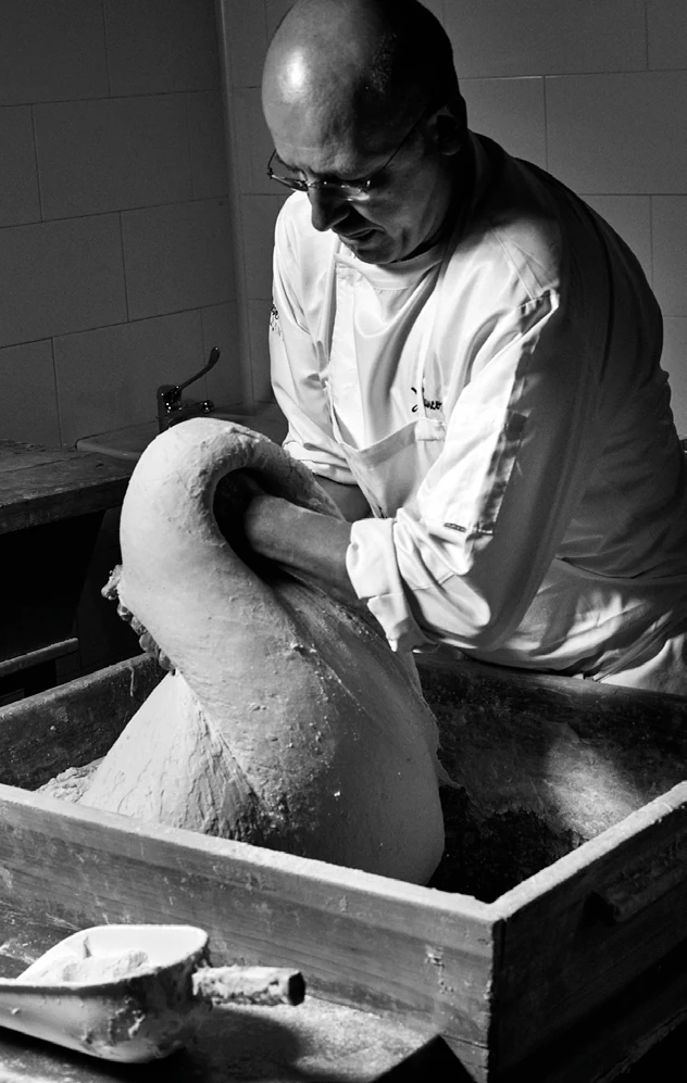 Persona che lavora l’impasto, in bianco e nero.